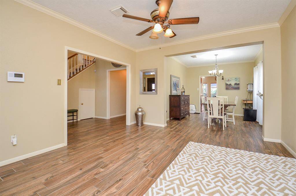 FORMAL LIVING ROOM WITH CROWN MOLDING & CEILING FAN