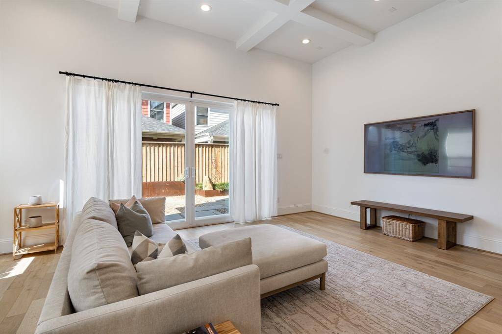 Step into the inviting living area, where soaring 12-foot ceilings and wide plank wood floors create a bright and airy ambiance. Oversized patio doors lead to the backyard, blending indoor comfort with outdoor charm.
