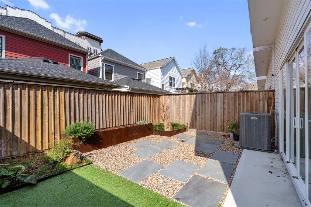 thoughtfully designed backyard with stone pavers, decorative gravel, and raised garden beds. This low-maintenance space is perfect for outdoor relaxation or entertaining guests.