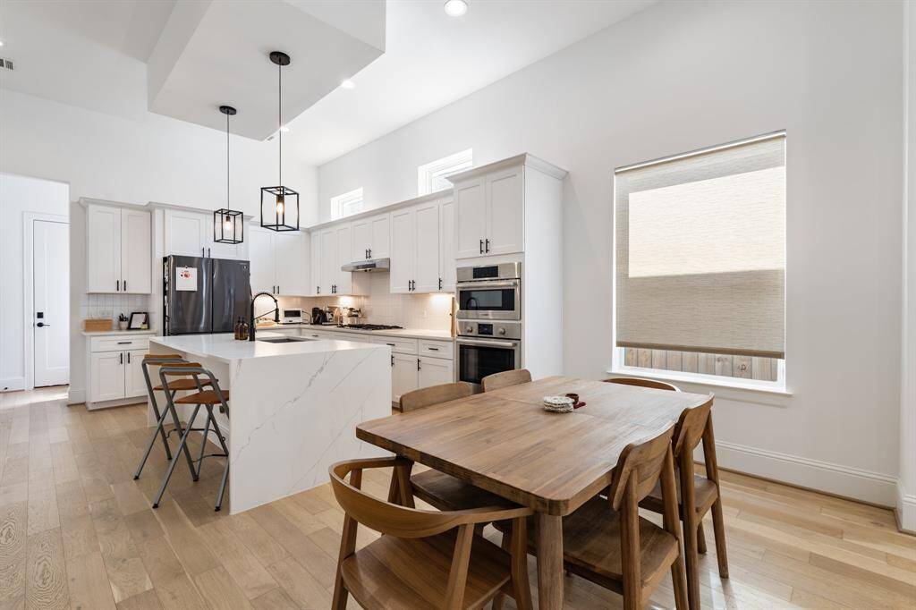 A chef’s dream, the kitchen features a striking quartz island with waterfall edges, sleek Bosch stainless steel appliances, and soft-closing cabinetry. It’s a space designed for both culinary creativity and gathering with loved ones.