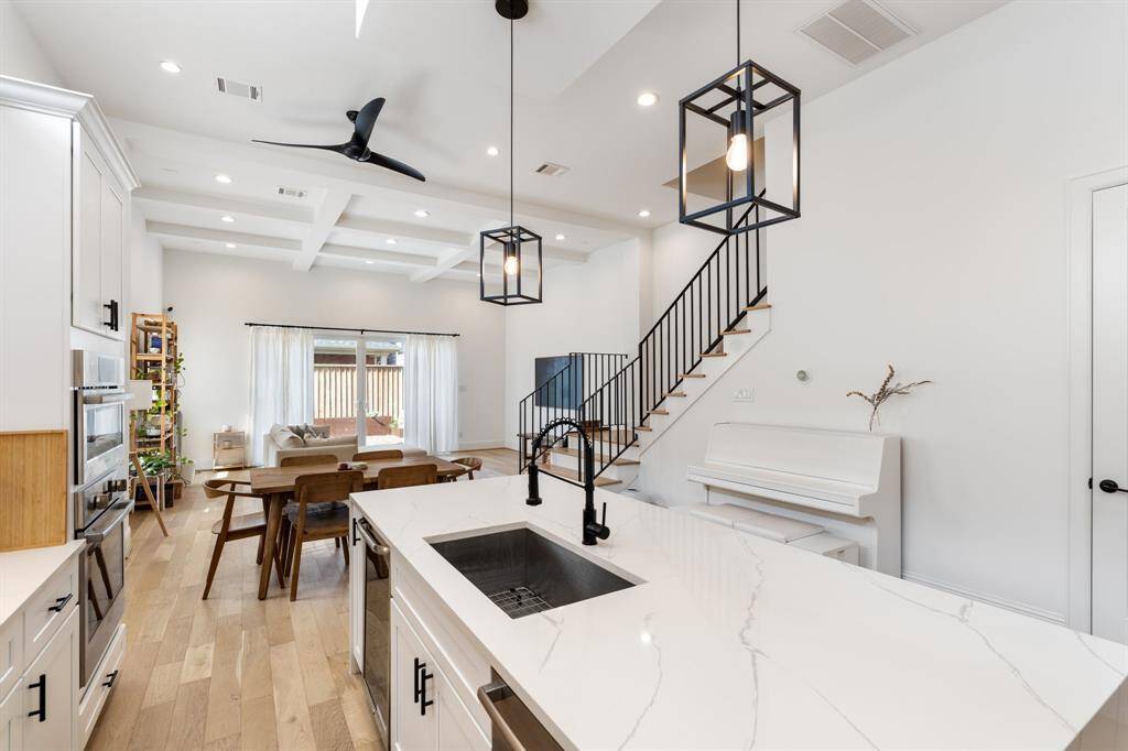 A perfect blend of style and function, the open kitchen overlooks the dining and living areas, making hosting effortless. The sleek iron-railed staircase leads to the second floor, where private retreats await.