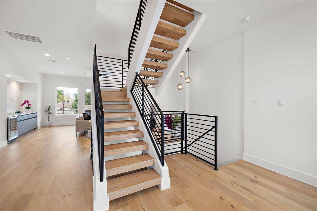 This modern staircase is a stunning focal point, featuring sleek, minimalist design with floating steps and a striking metal railing. Its open-concept style enhances the flow of natural light, creating a sense of space and elegance. A true architectural highlight that adds sophistication and character to the home