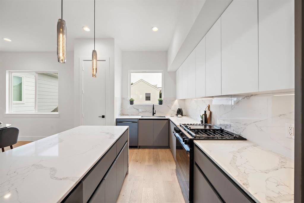 The cabinets' soft-close drawers enhance the clean, streamlined design, while the quartz countertops add durability and a touch of elegance.