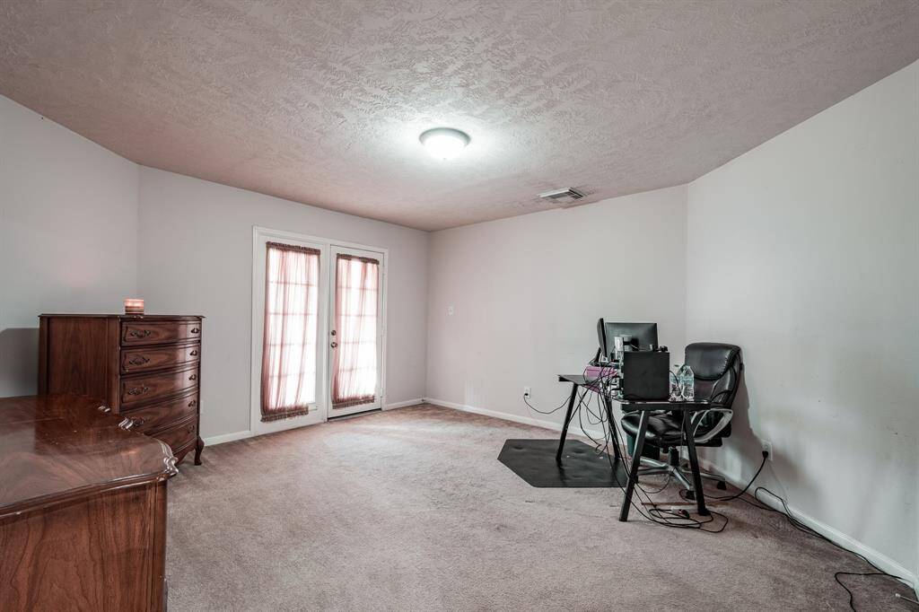Secondary bedroom with double doors leading to covered porch