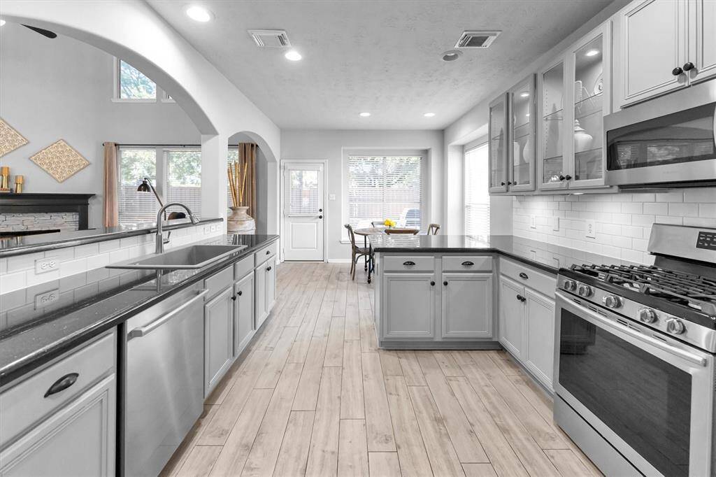 Kitchen boasts custom glass front cabinets,granite countertops , stainless appliances,farm sink, and ample storage