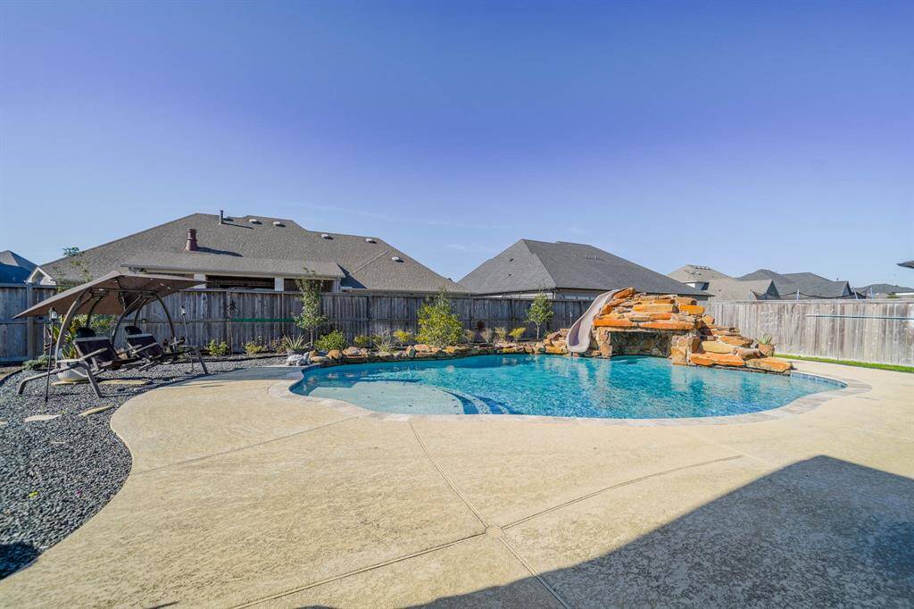 Custom heated pool with water slide, cave and four water features to include multiple water falls!