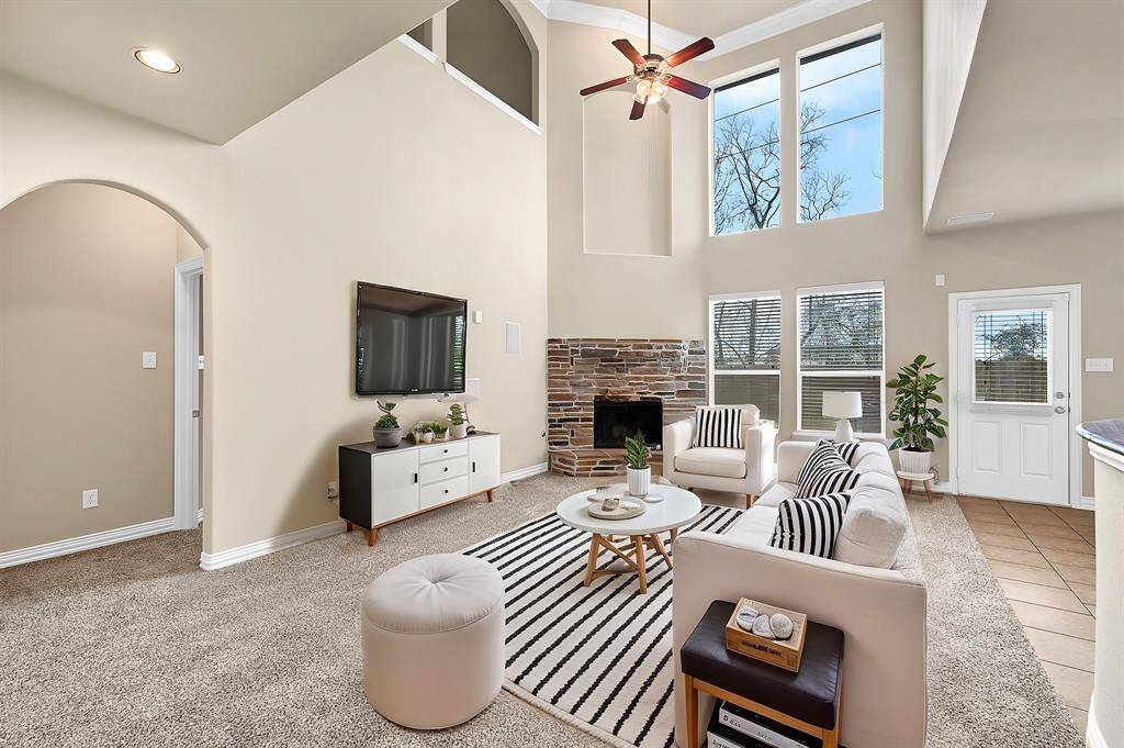 Stone covered wood burning fireplace with high ceiling and large windows. **Virtually Staged