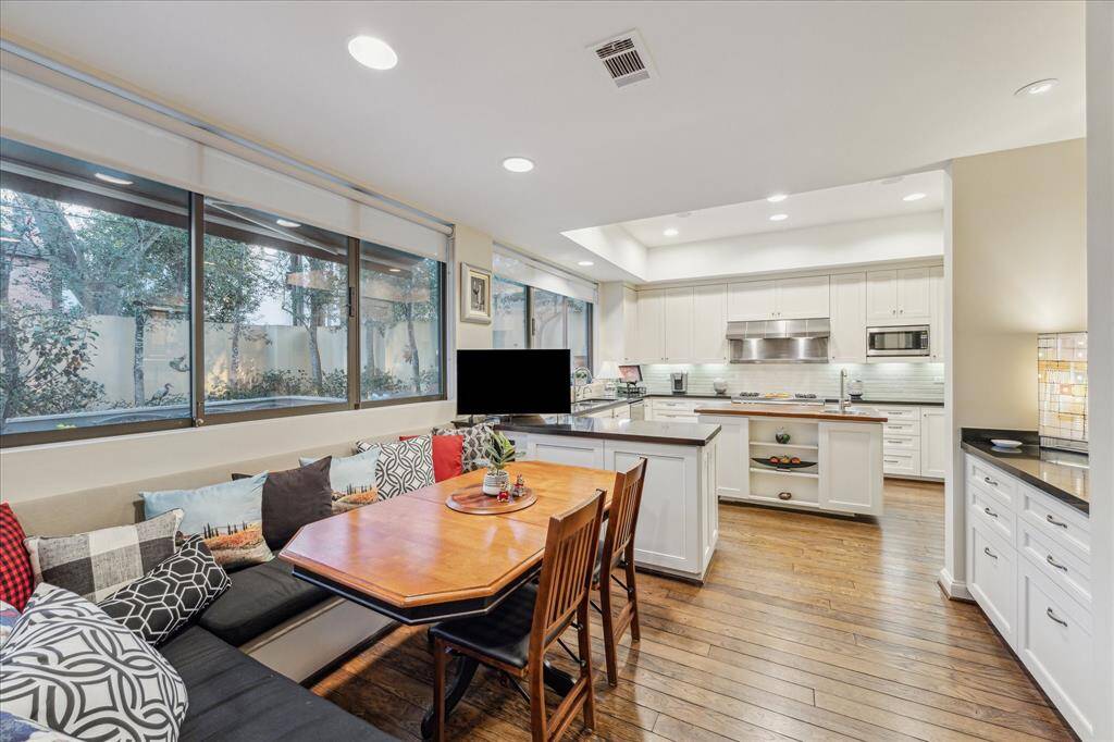BREAKFAST AREA-This custom built L shaped breakfast space is open to the kitchen and the perfect place to start your down or wind do your evening. The cushions and table will remain with the home.
