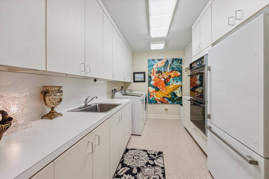 LAUNDRY ROOM-This large space features double ovens, a sink and a recent 2nd refrigerator that will stay with the house. This area would also be perfect for a catering kitchen.