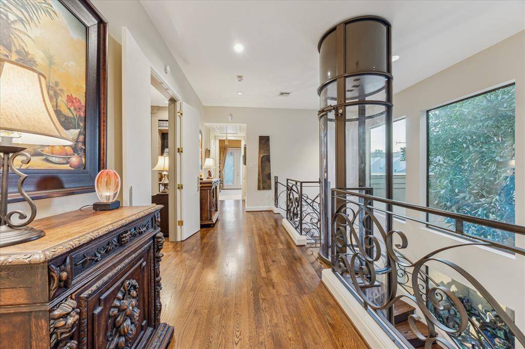 Expansive second floor landing with wood floors and large picture windows with treetop views.