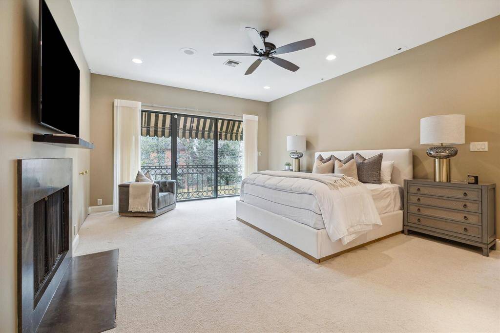 PRIMARY BEDROOM-This luxurious retreat features a gas log fireplace with marble surround, reading lights, remote controlled shades and a Juliet balcony.
