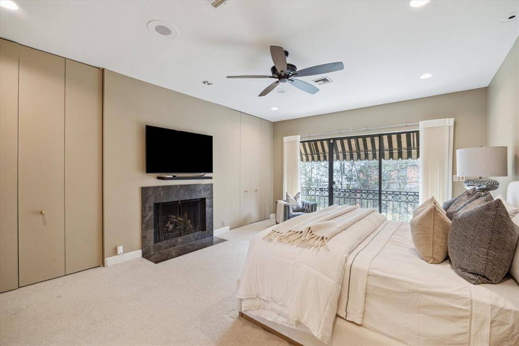 PRIMARY BEDROOM II-Another perspective of the primary bedroom which features 2 walk-in closets as well as hidden closet space that flank each side of the fireplace. The television will remain with the home.