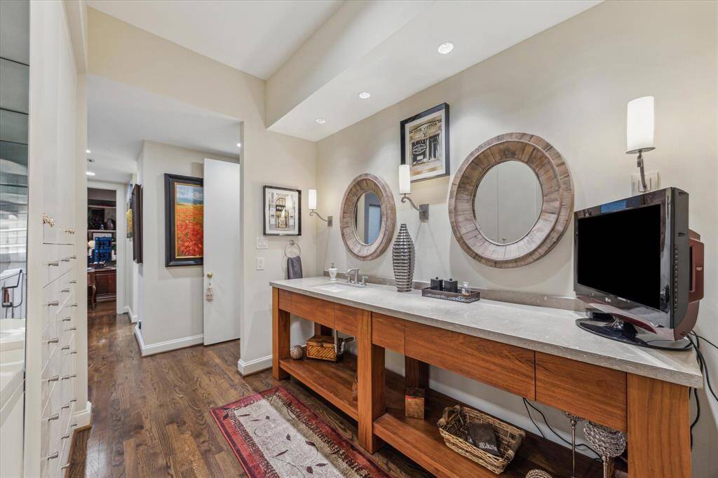 PRIMARY BATH-Renovated spa-like bath with separate vanity areas. This space features a custom vanity with limestone countertop, custom mirrors and an abundance of built-ins.