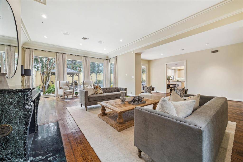 LIVING AREA II-Another perspective of this gorgeous room that is open to the kitchen. This space also features floor to ceiling windows with backyard views, custom window treatments, bold crown molding and art lighting.