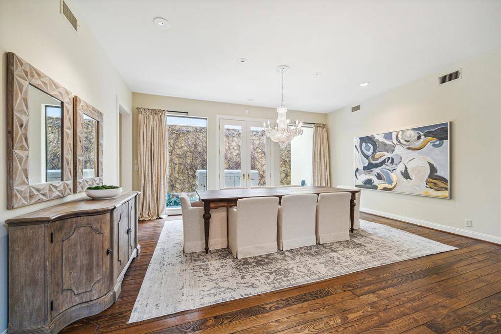 DINING ROOM-This large area features wood floors, large glass panel doors and windows, custom window treatments and art lighting. The home also features newly upgraded LED lighting througout with LUTRON dimmers.