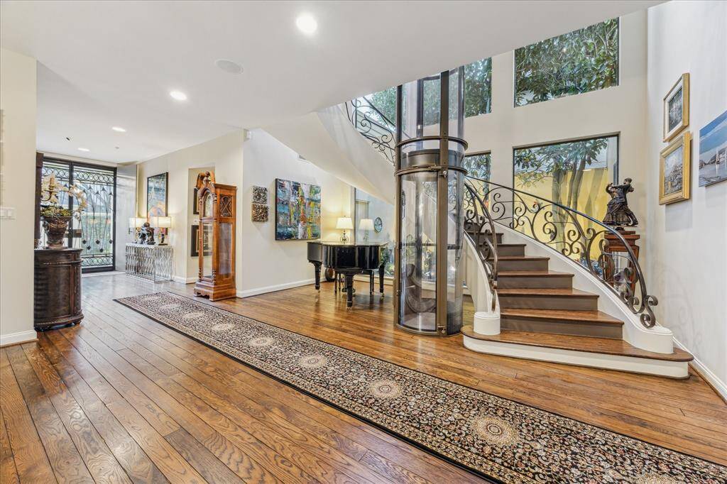This striking view shows the recently installed hydraulic elevator. This is great when you have had a long day or even if you want to send your luggage or other belongings up and down. Make note of the grand floating staircase, the soaring ceiling and the large picture windows looking out to the Zen garden that brings the outdoors in.