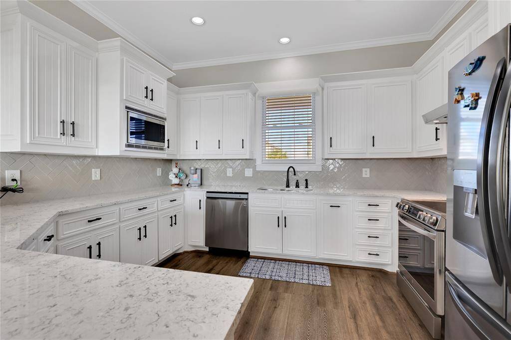 The beautiful updated kitchen is light and bright with corian counter tops. Stainless steel appliances.