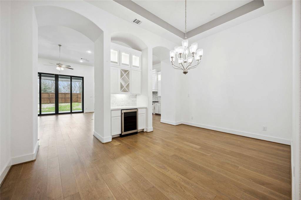 View of formal dining room with wine fridge and living room and kitchen in the background
