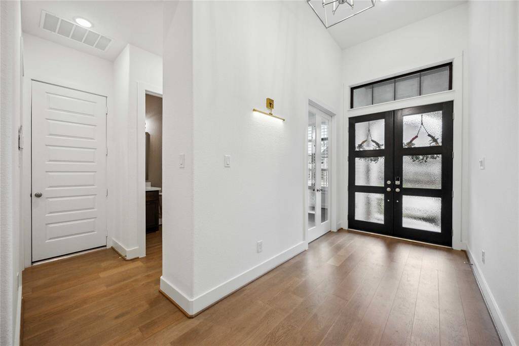 View of garage entry, front door, half bath and office entry