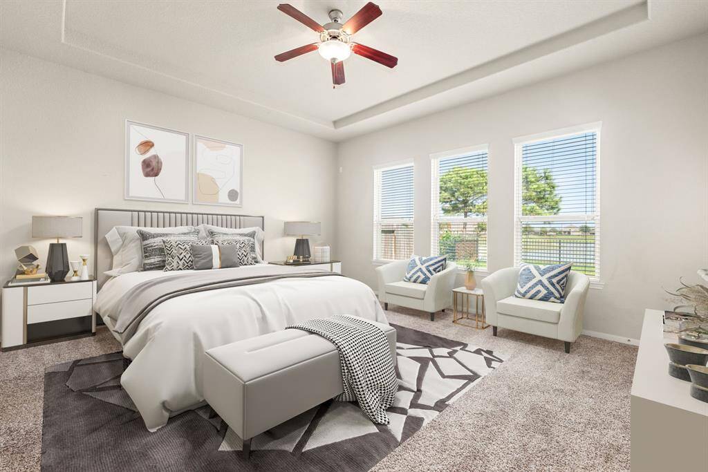 What a wonderful place to come home to, this stunning primary suite greets you with plush carpet floors, a warm neutral paint, trey ceiling, ceiling fan with lighting, lovely windows with blinds allowing in natural light brightening up this spacious primary bedroom, with extra space for a seating area.