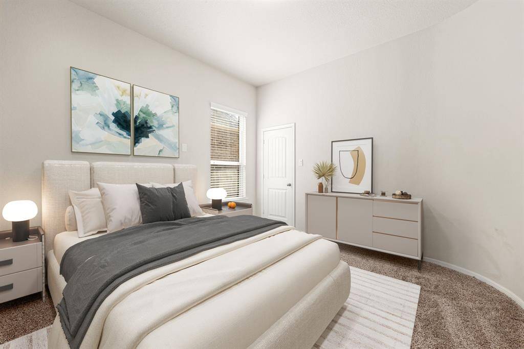 Secondary bedroom, located downstairs, great for use as an in-law suite or guest suite features high ceilings, neutral paint, plush carpet, space for seating area, direct access to the secondary bathroom and large window with privacy blinds.