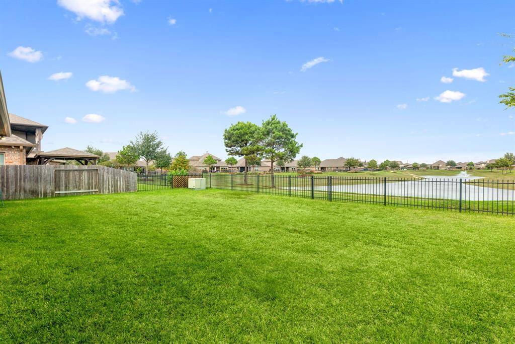 Sit back, relax and enjoy your gorgeous backyard overlooking the lake under your large covered patio. Complete with outdoor fan and recessed lighting, plenty of space for an outdoor kitchen or grilling station and outdoor seating. Your covered patio overlooks your huge backyard with plenty of green space for the kids and your furry friends to enjoy.