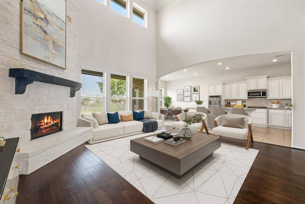 This living room is more like a GREAT room featuring a stunning stone fireplace with mantel detailing, neutral paint, soaring high ceiling, recessed lighting, and an amazing wall of windows providing a lovely view of your backyard to keep an eye out on the kids or pets playing.