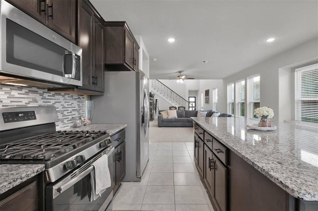 This photo showcases a modern open-concept kitchen and living area with large island perfect for entertaining