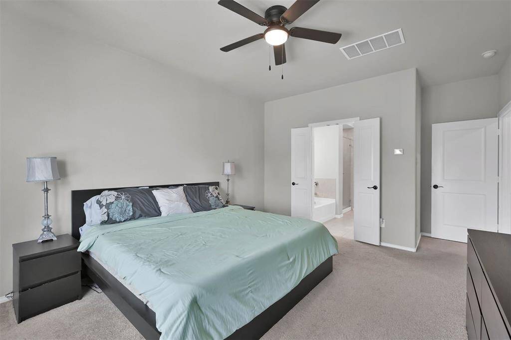 Spacious primary leads to ensuite bathroom with double doors
