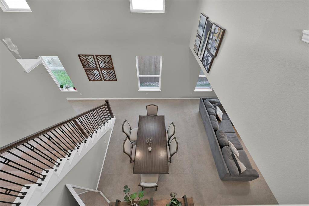 View from upstairs gameroom showcasing high ceilings with ample natural lighting