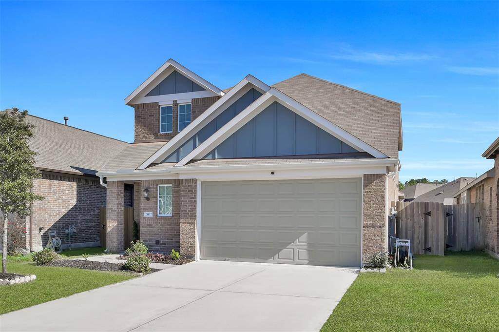 Modern, two-story brick home with a two-car garage features a well-maintained front yard and a clean driveway, offering a welcoming curb appeal