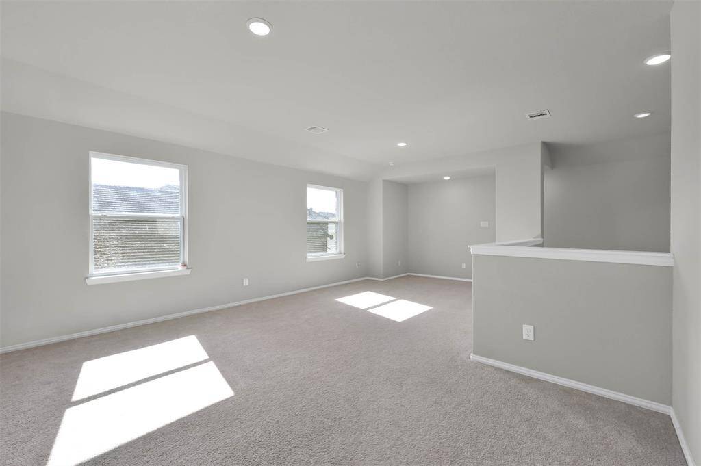 The open layout includes a partial dividing wall, offering flexible use of the space leading into guest bedrooms