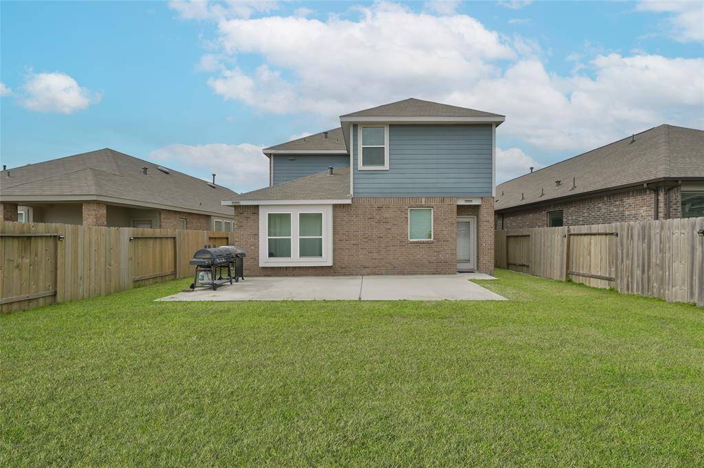 Featuring a spacious lawn, concrete patio, & is enclosed by wooden fencing, offering privacy & a cozy outdoor space.