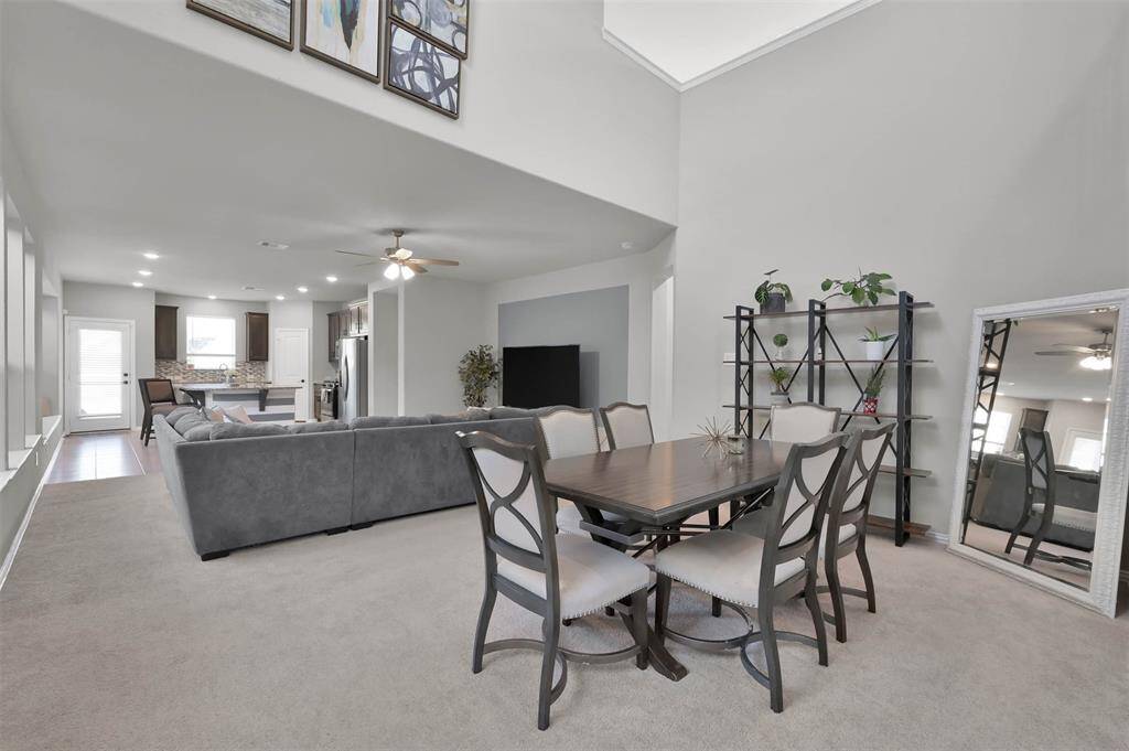 Spacious open-concept living and dining area with high ceilings. Ample natural light and stylish decor elements add to the inviting ambiance.
