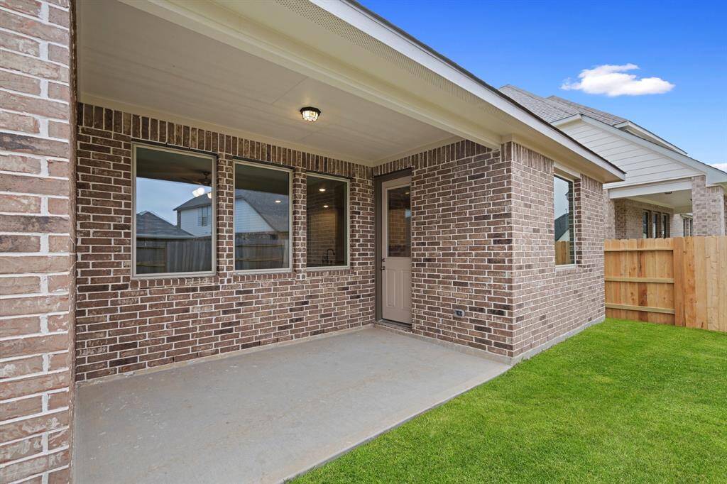 The covered patio is generously sized, providing ample space for various outdoor activities.