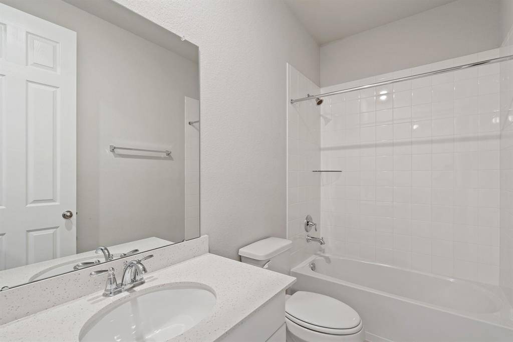 The secondary bath features tile flooring, white cabinetry and light countertops and a shower/tub combo. Perfect for accommodating any visiting family and friends.