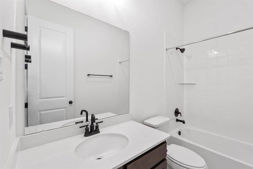 The secondary bath features tile flooring, white cabinetry and light countertops and a shower/tub combo. Perfect for accommodating any visiting family and friends.