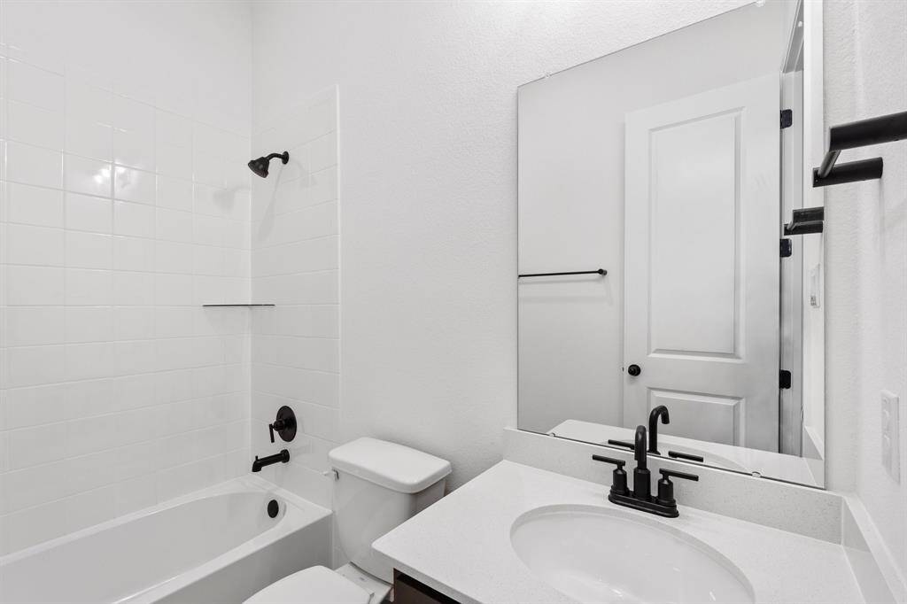 The secondary bath features tile flooring, white cabinetry and light countertops and a shower/tub combo. Perfect for accommodating any visiting family and friends.