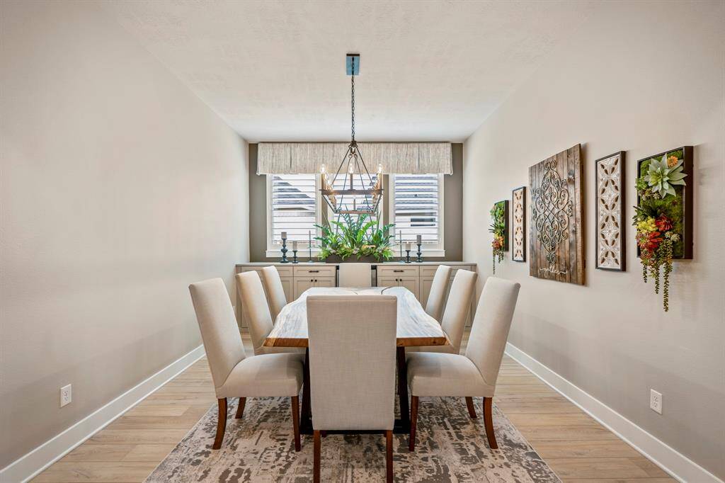 Make memories gathered around the table in the spacious dining room, complete with custom built-in cabinets and wine fridge! This dining room features custom window coverings, an updated chandelier, and wood shutters!