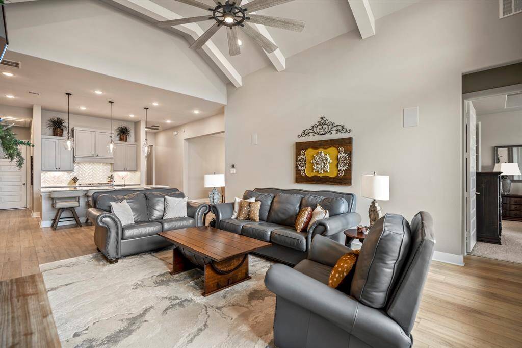 Gather the family and guests together in your huge living room! Featuring built-in surround sound speakers, high ceilings with painted beams, a modern chandelier, luxurious wood like flooring, and an open layout.