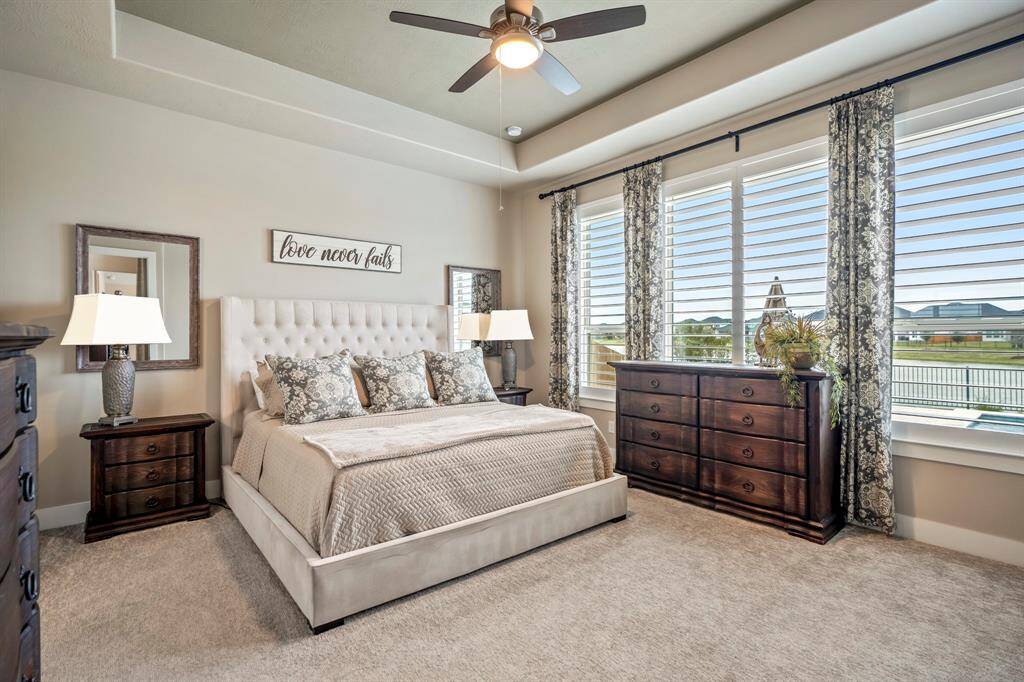 Wake up to breathtaking lake and pool views from the serene primary suite! This private retreat boasts expansive windows that fill the space with natural light, bringing the beauty of the outdoors in.