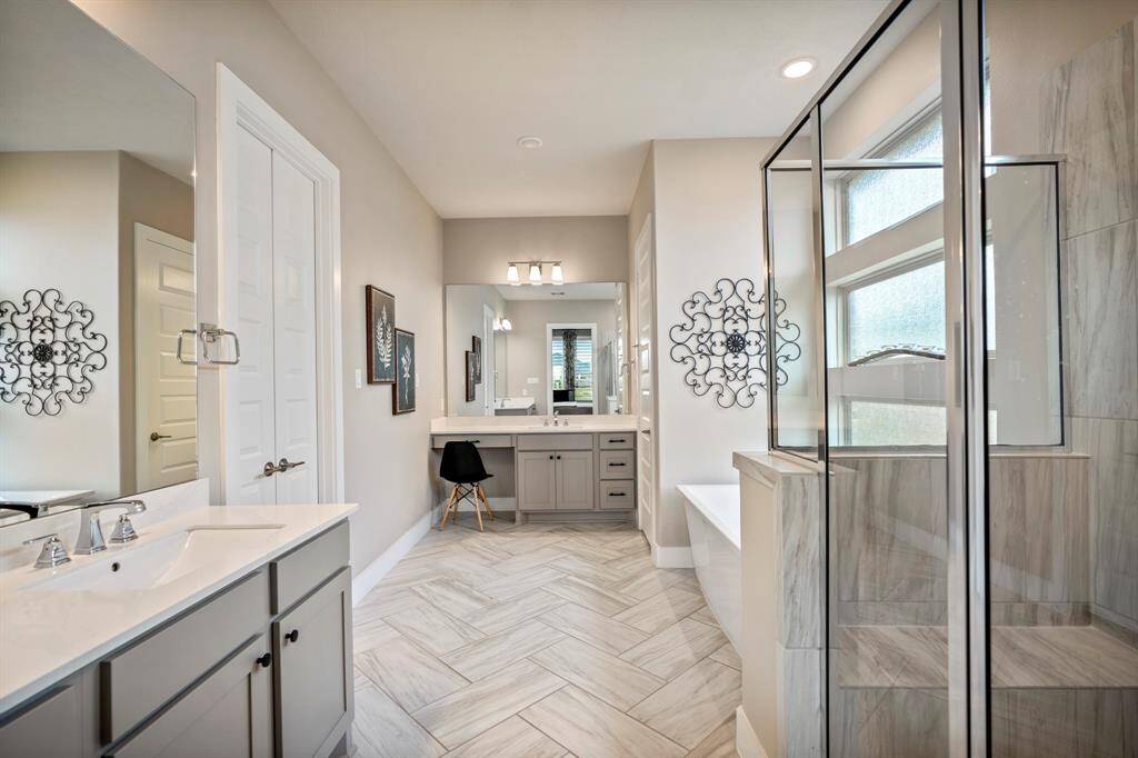 Indulge in the spaciousness of this primary bathroom featuring two separate vanities, complete with quartz countertops, painted cabinets, and a vanity area.