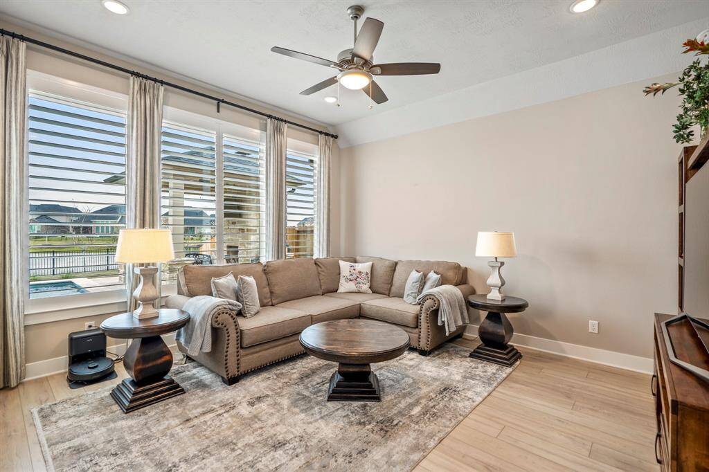 With a scenic backyard and lake view, this spacious game room is perfect for movie nights, game days, or just hanging out. Featuring wood shutters, recessed lighting, a ceiling fan, and access to the back patio!
