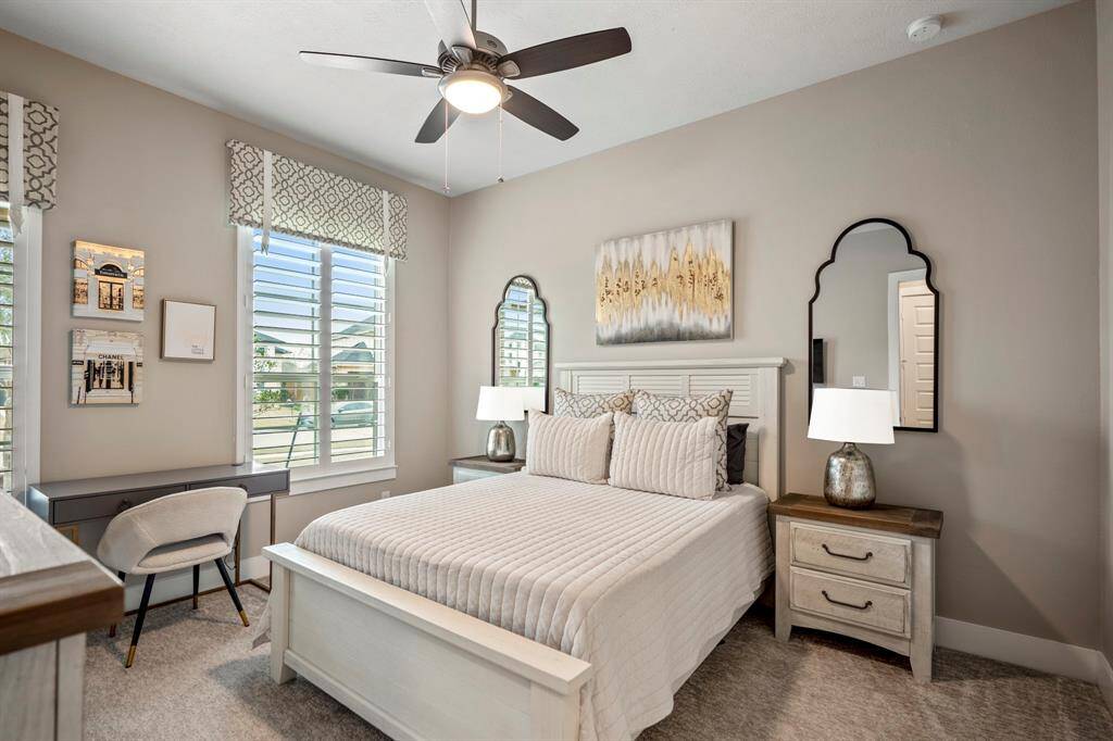 Bright and inviting, this spacious secondary bedroom offers plenty of room for relaxation and personalization, making it the perfect retreat for family or guests. Complete with plush carpet, wood shutting, and ceiling fan.
