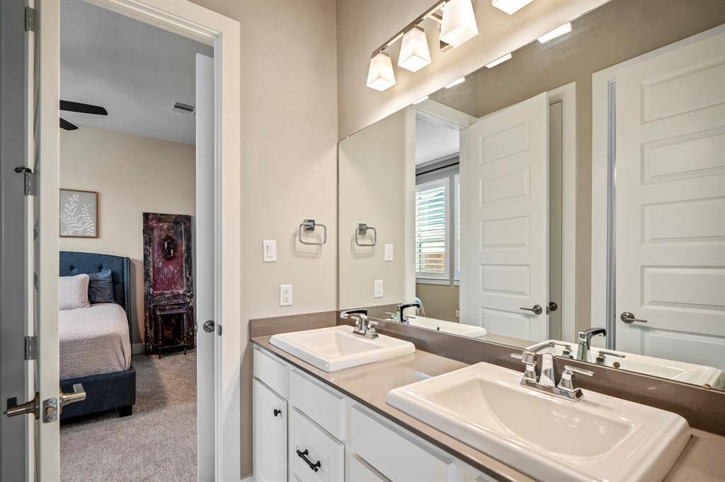 Connecting the secondary bedrooms, this full bathroom offers additional privacy with separated vanity and shower making it easy to share and get ready. It features with white cabinets, a spacious tub and shower, dual sinks, and large mirror.