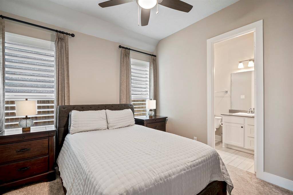 Cozy and private, this secondary bedroom includes plush carpet and bright natural light. It comes with its own en-suite bathroom featuring elegant quartz countertops, a large combination tub and shower, and a spacious vanity — the perfect retreat for comfort and convenience.