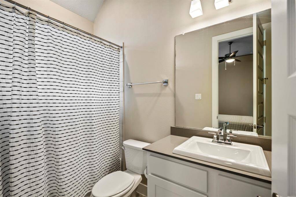Featuring sleek quartz countertops, a spacious vanity, and a tub-shower combo, this bathroom offers both convenience and elegance. The perfect private retreat!