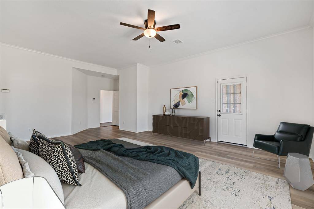Spacious primary suite featuring elegant flooring, ample natural light, and direct outdoor access for serene relaxation.