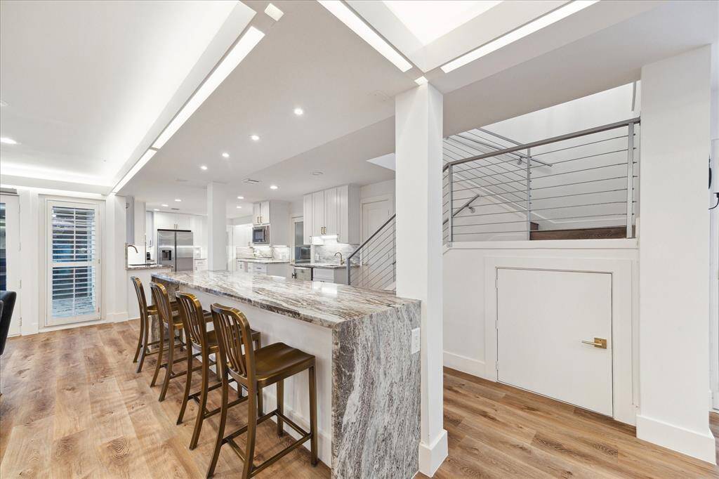 The dining area offers an extended marble topped bar with bar seating on the dining side and ample storage on the other.