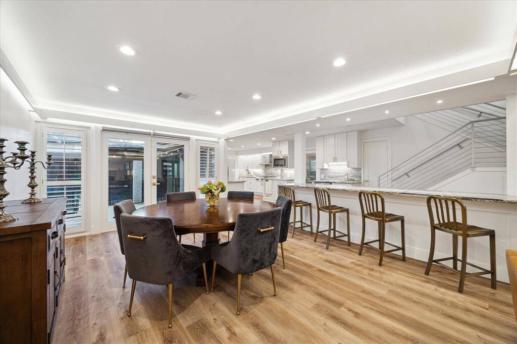 Gather them around your table to honor old traditions and create the new. This elegant formal dining room is perfect for hosting holiday parties and special occasions. Featuring an extended bar with seating on one side and storage on the other, ample space for a banquet table and sideboard, ambient lighting, and beautiful LVP flooring, this space may inspire you to entertain more often.